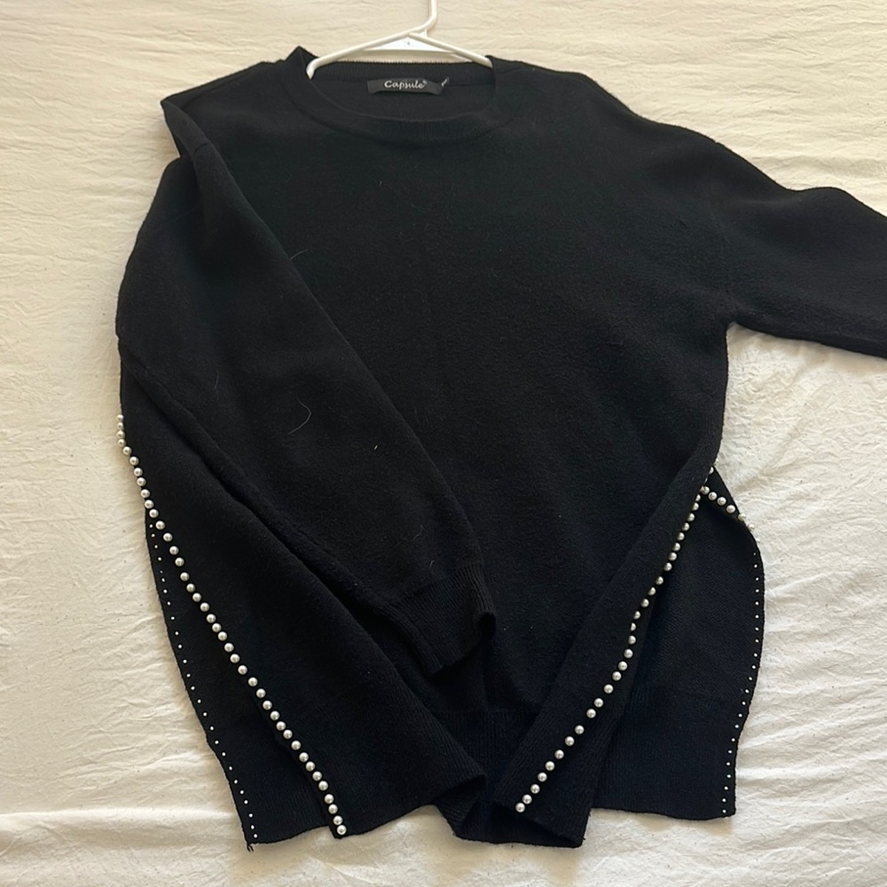 Cashmere black sweater open on the sides with pearl detailing. Barley worn.